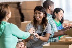 Smiling volunteers prepare food parcels