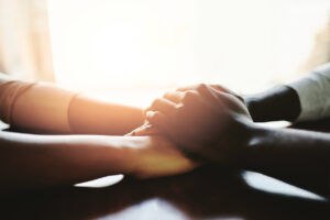 Closeup shot of two people holding hands in comfort