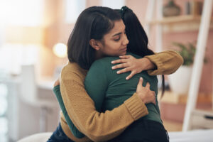 Two women embracing each other